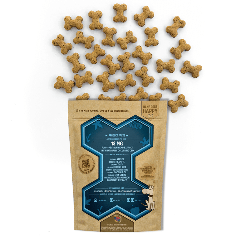 Golden brown baked dog bones dotted with black chia seeds spilling out of a Kraft BakedBones bag with a blue bone and ingredients listed on the back