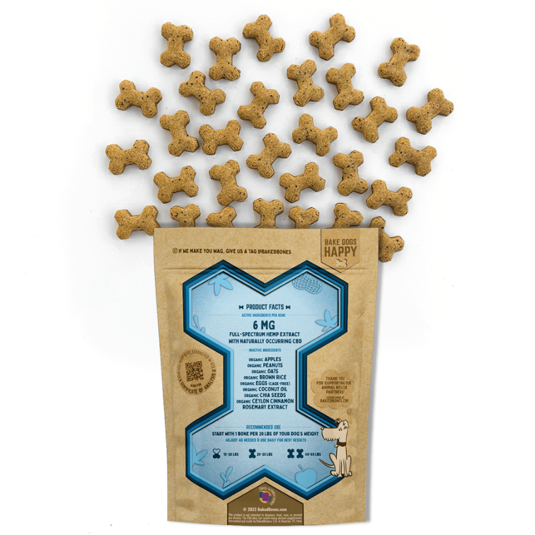 Golden brown baked dog bones dotted with black chia seeds spilling out of a Kraft BakedBones bag with a blue bone and ingredients listed on the back