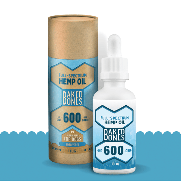 A white bottle with a blue and white label indicating that it contains 600 mg of full-spectrum CBD oil, sitting in front of its packaging, which is a kraft tube with a blue and white label indicating “full spectrum hemp oil for dogs containing 900mg of CBD.”